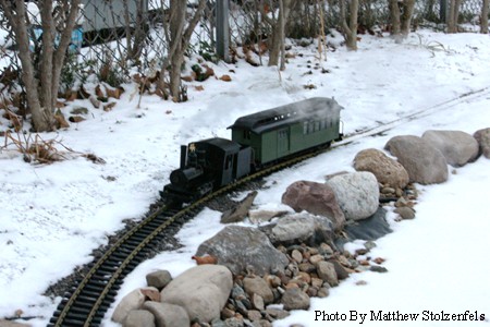 the daily passenger train runs next to a snow covered lake